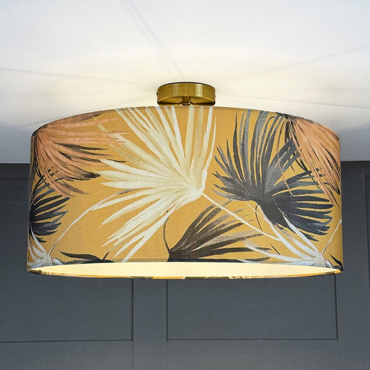 Ceiling light fixture with a tropical leaf patterned shade against a neutral background