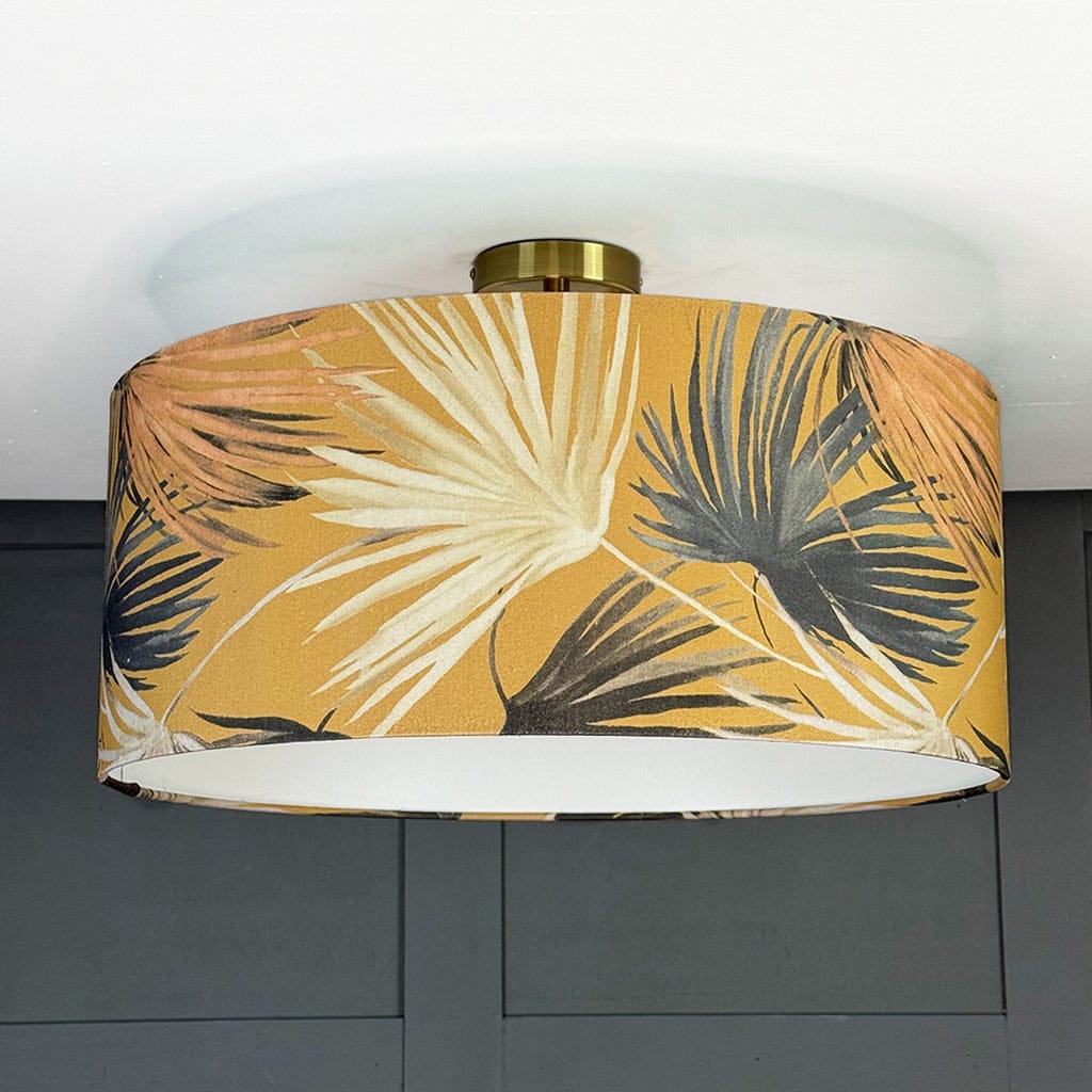 Ceiling light fixture with a tropical leaf patterned shade on a gray wall background