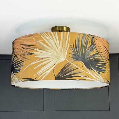 Ceiling light fixture with a tropical leaf patterned shade on a gray wall background