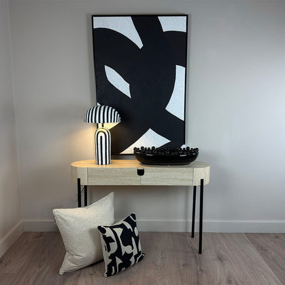 Modern interior with a console table, abstract art, and decorative items.
