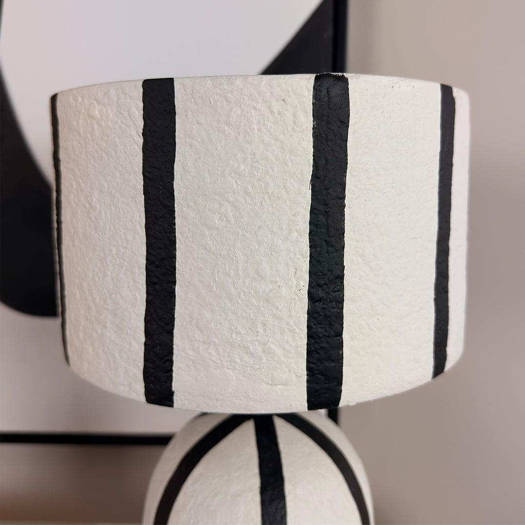White lampshade with black stripes on a blurred background