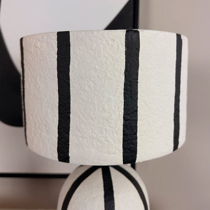 White lampshade with black stripes on a blurred background