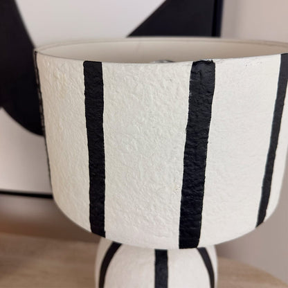 White vase with black stripes on a blurred background