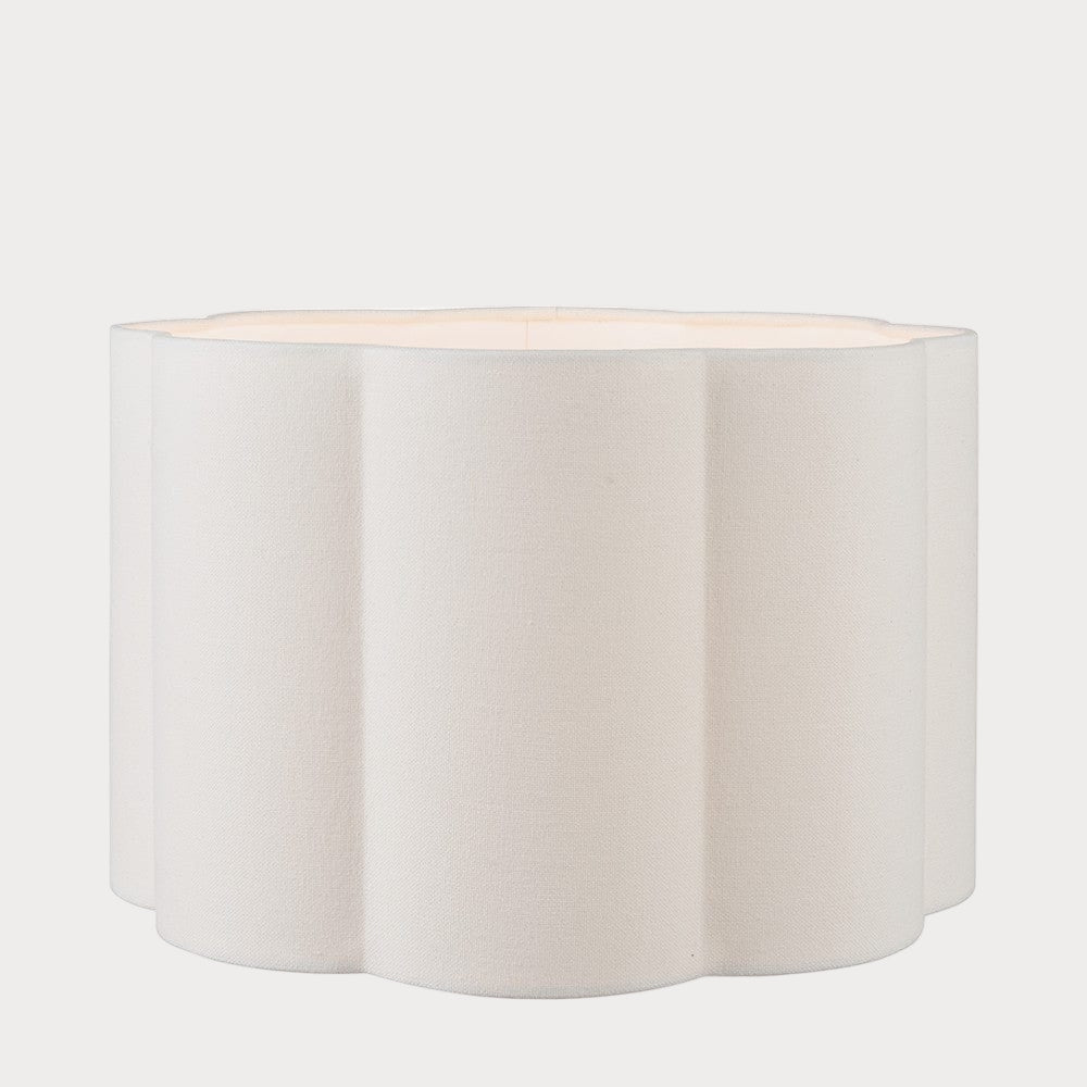 A cylindrical scalloped lampshade with a white finish, displayed against a neutral background.