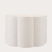 A cylindrical scalloped lampshade with a white finish, displayed against a neutral background.