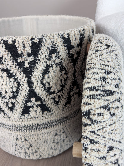Textured black and white patterned ottoman against a neutral background
