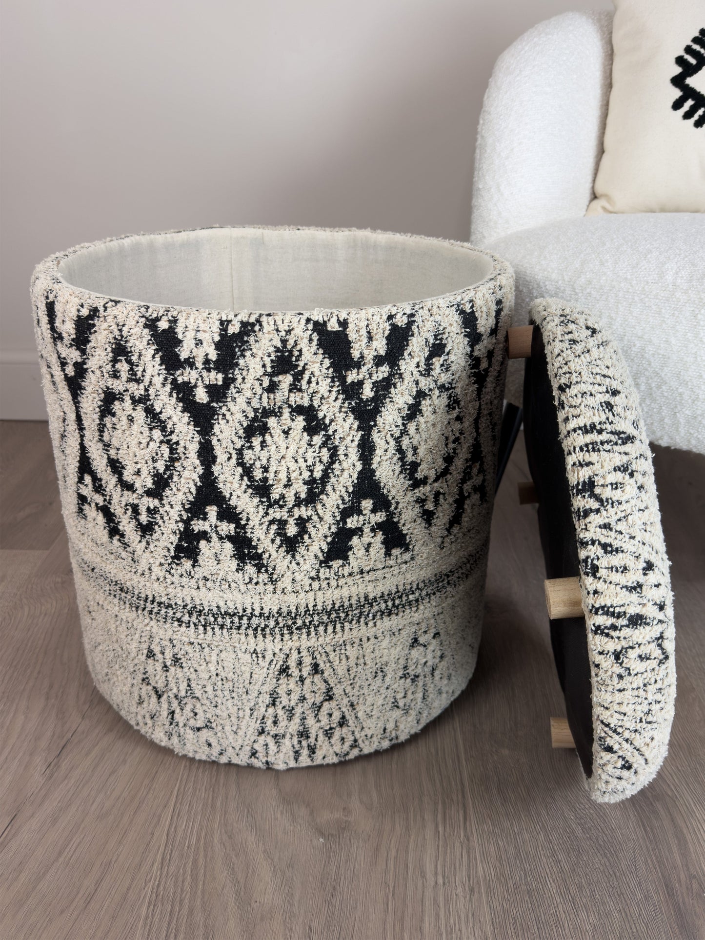 Tufted storage ottoman with geometric pattern on a wooden floor