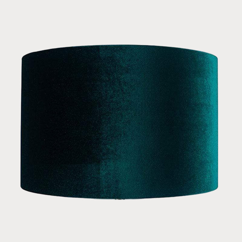 A cylindrical velvet lampshade in green color with a bronze lining, displayed against a plain background.