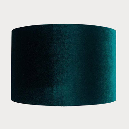 A cylindrical velvet lampshade in green color with a bronze lining, displayed against a plain background.