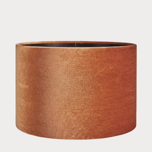 A cylindrical velvet lampshade in orange color with a bronze lining, displayed against a plain background.