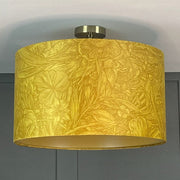 A custom lemon yellow lampshade with a floral pattern, mounted on a ceiling rod.