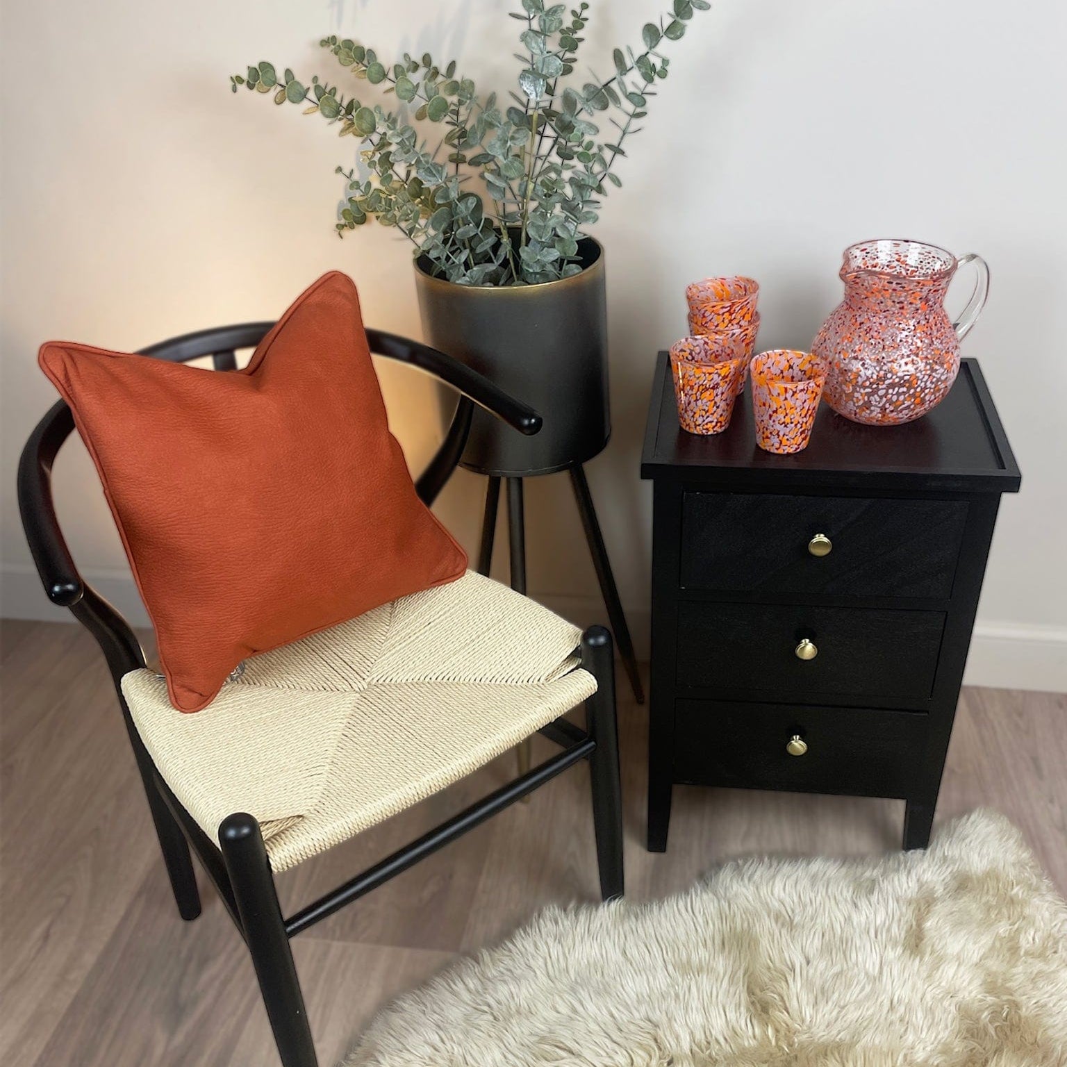 Chair with an orange cushion and a small table with decorative items in a room.
