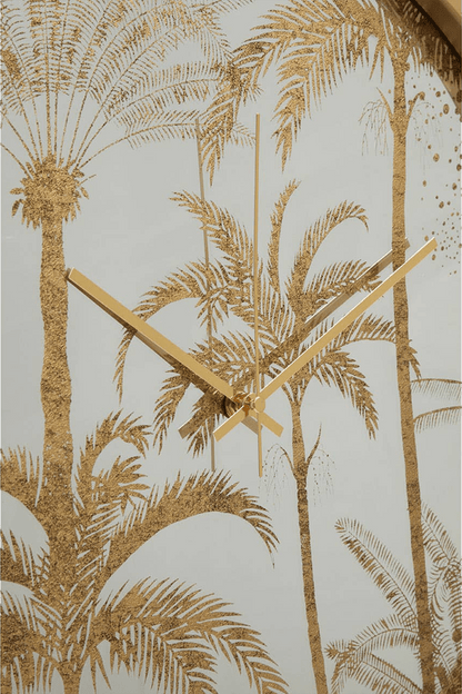 Gold clock with palm tree design on a light background