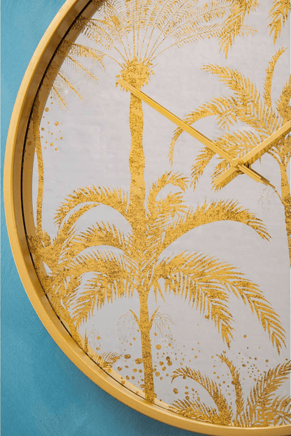Decorative wall clock with gold palm tree design on a blue background