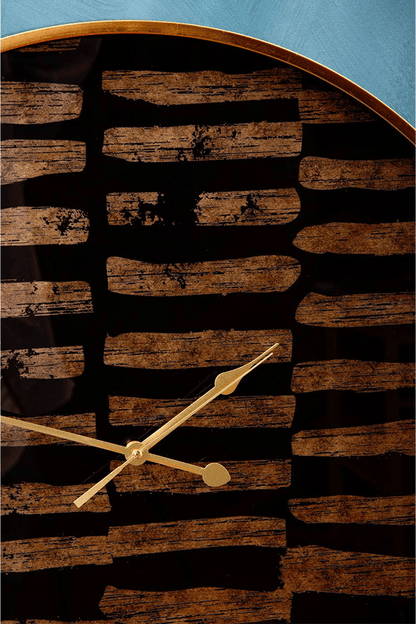 black and gold wall clock with a rustic design on a blue background