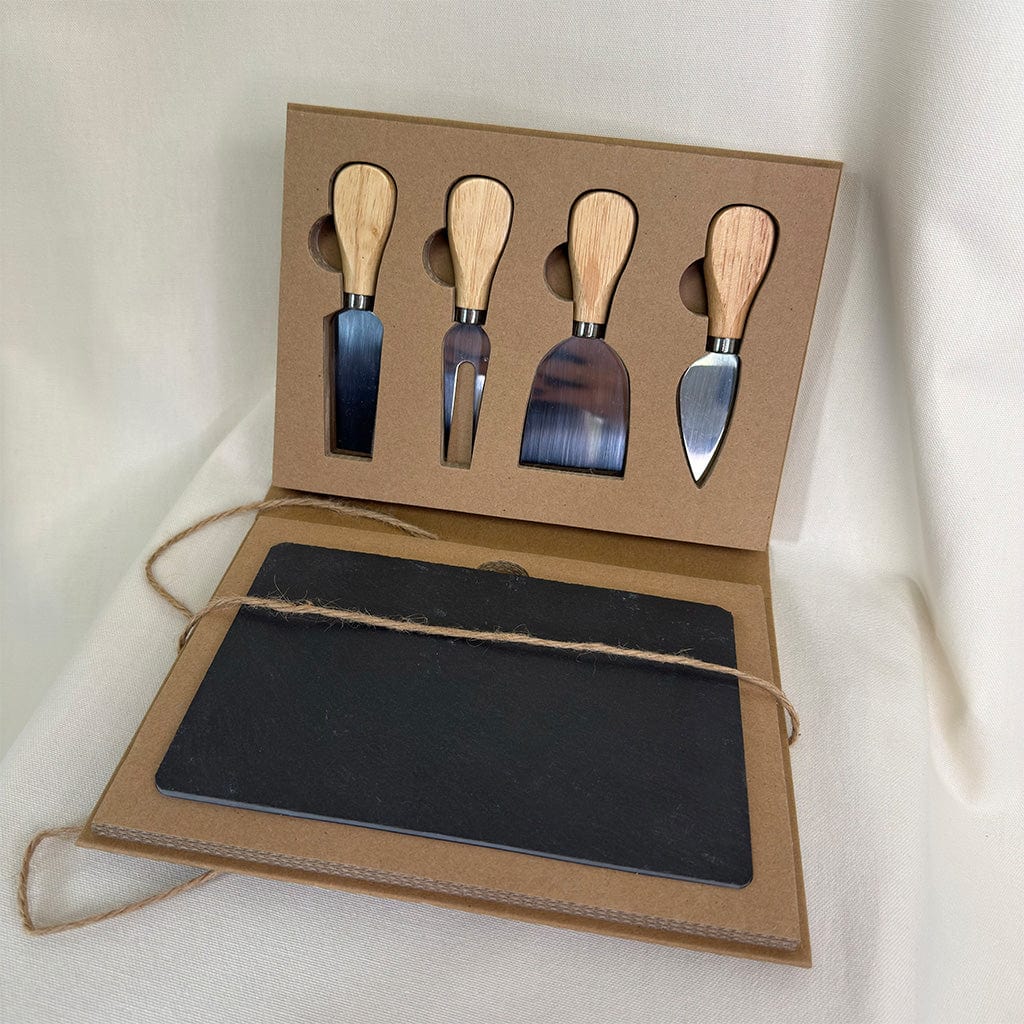 Set of four metal cheese knives with wooden handles in a cardboard box on a white background