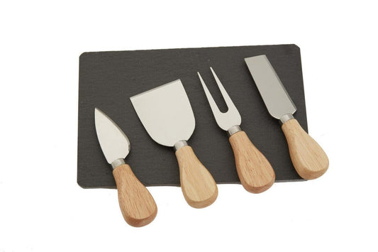Set of four cheese knives with wooden handles on a black slate board.
