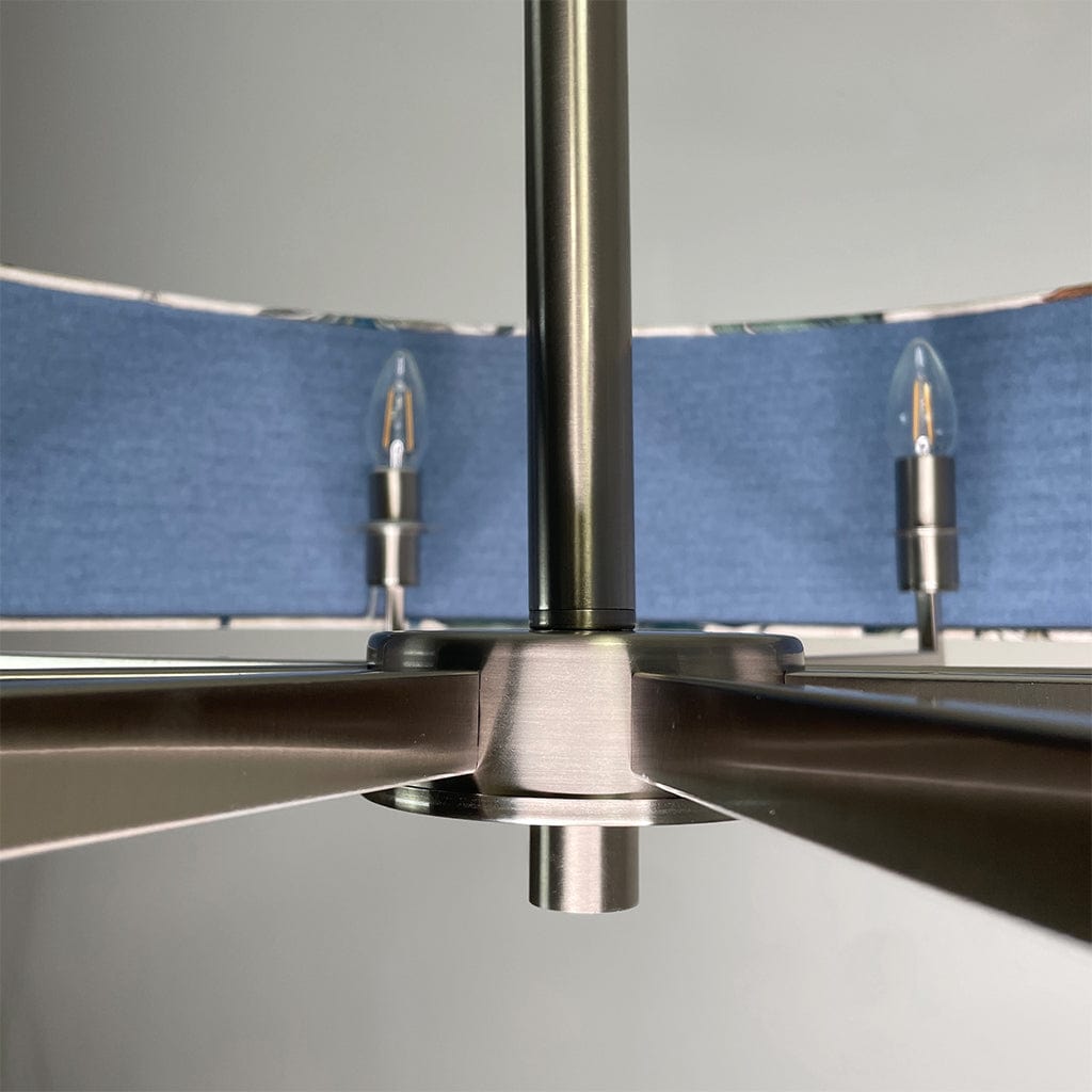 Close-up of a metallic ceiling fan with blue blades against a gray background