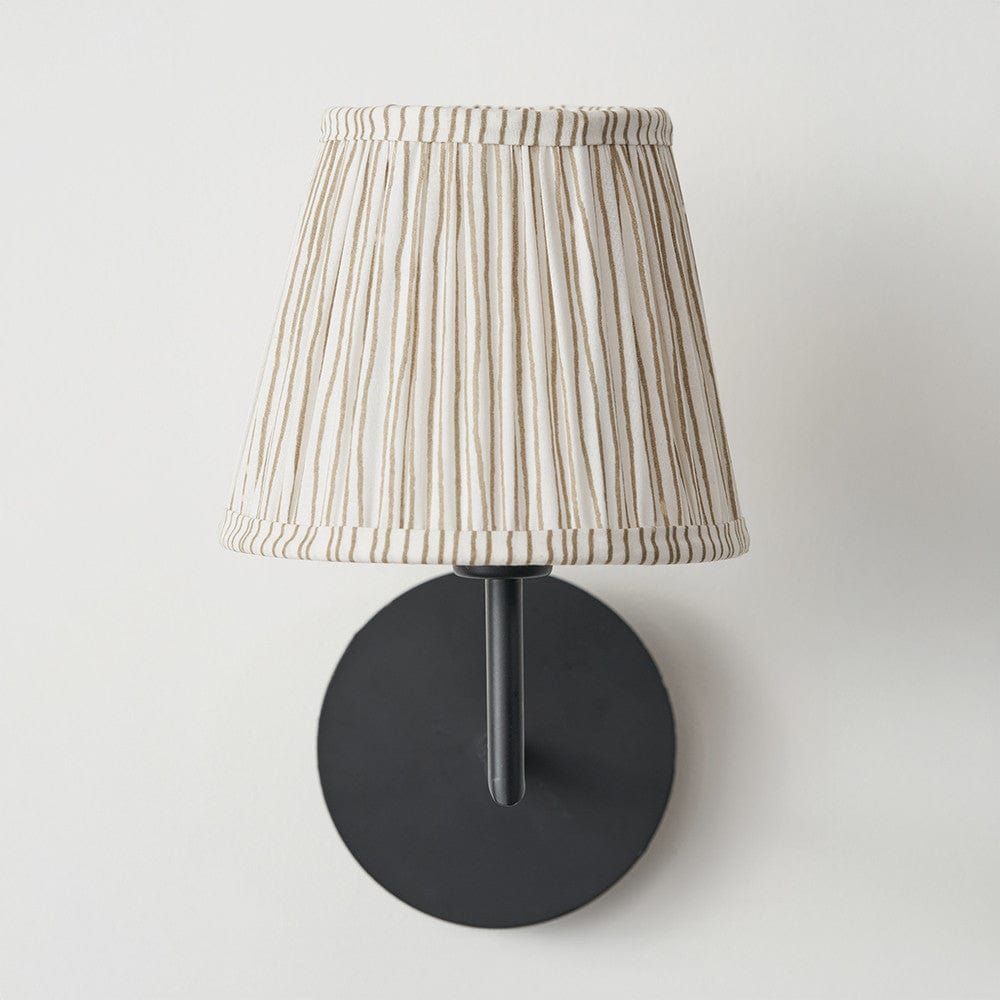 Wall-mounted lamp with a striped shade on a white background