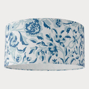 A cylindrical lampshade with a blue floral pattern on a white background.