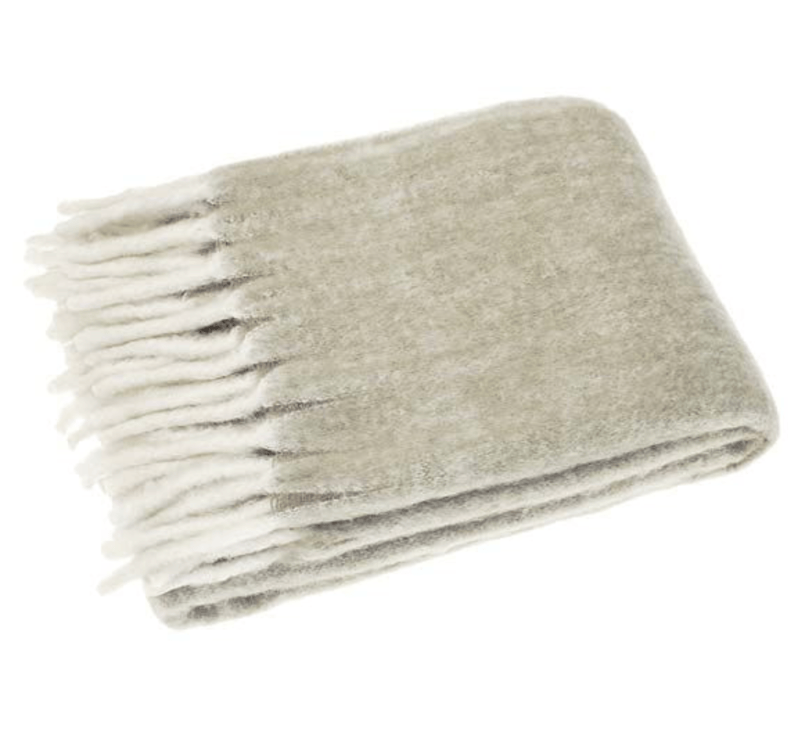 Folded gray blanket with white fringe on a white background