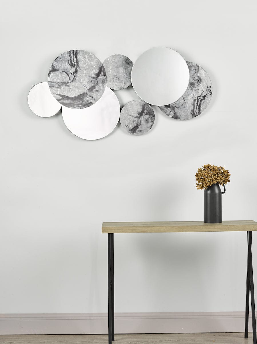 Decorative wall mirrors with marble pattern on a plain wall above a wooden console table.