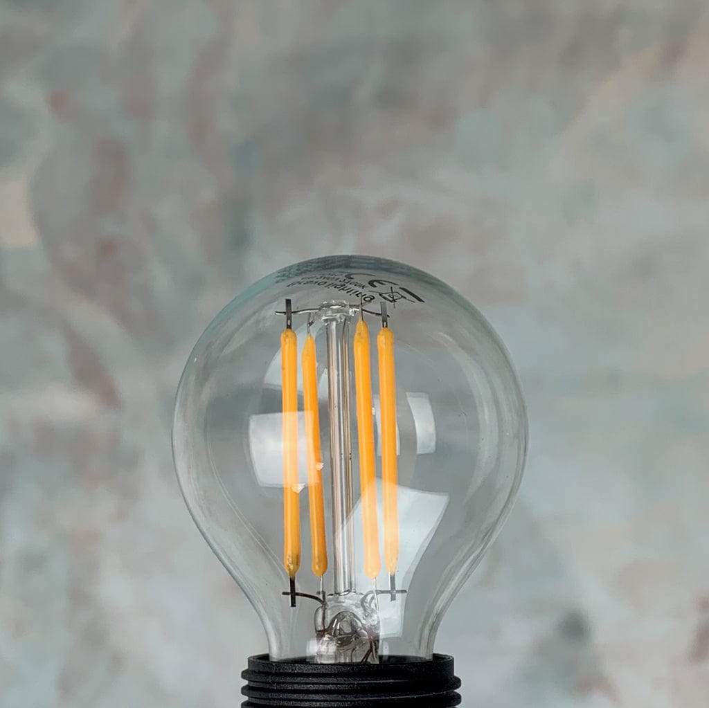 A clear, small Edison screw fitting LED golfball light bulb.
