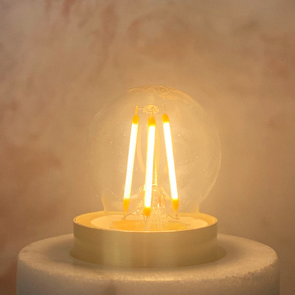 A clear E27 6.5W non-dimmable LED golfball-shaped light bulb with a silver E27 base, lit
