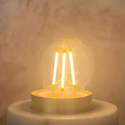 A clear E27 6.5W non-dimmable LED golfball-shaped light bulb with a silver E27 base, lit