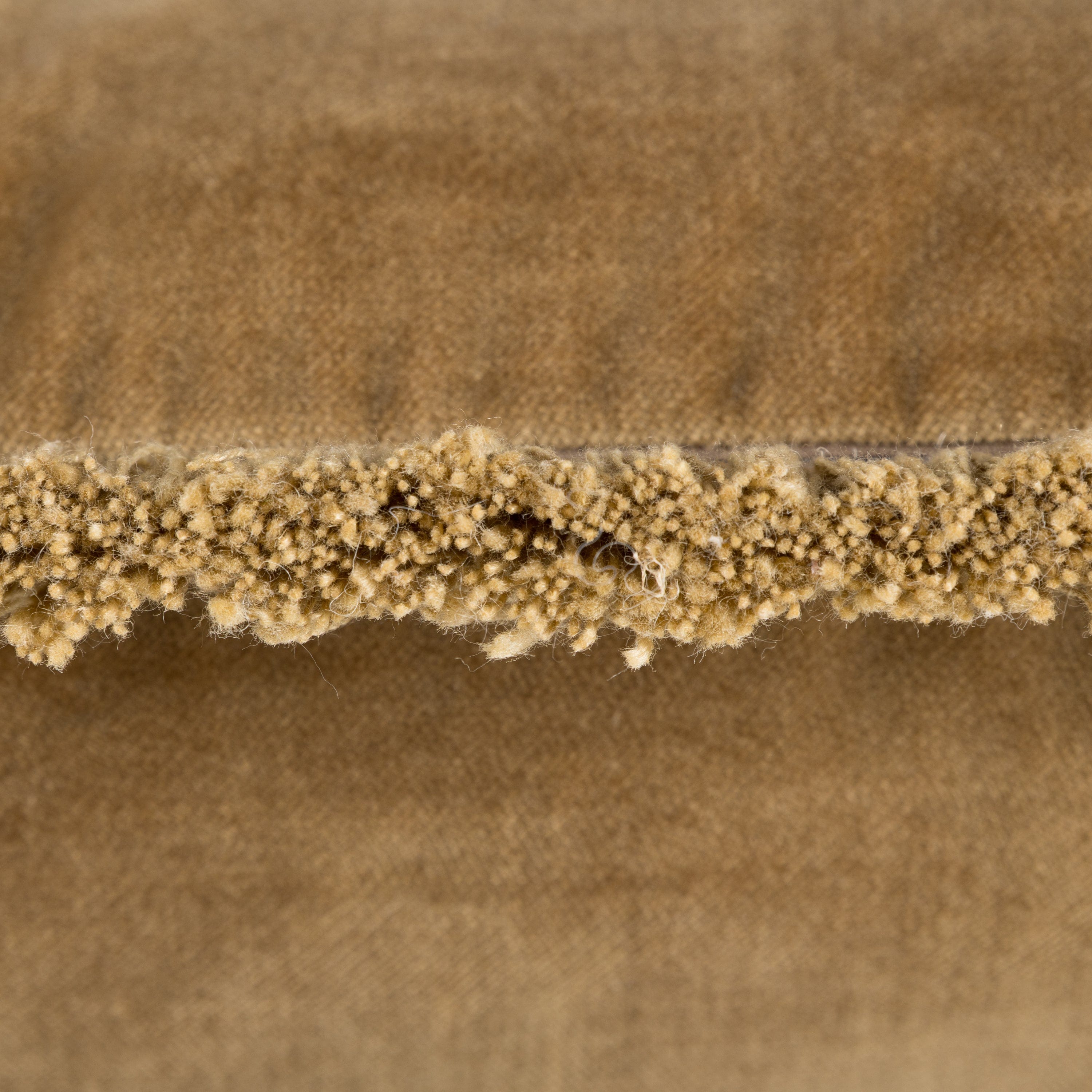 Close-up of brown/antique gold fabric with a textured tassel edge