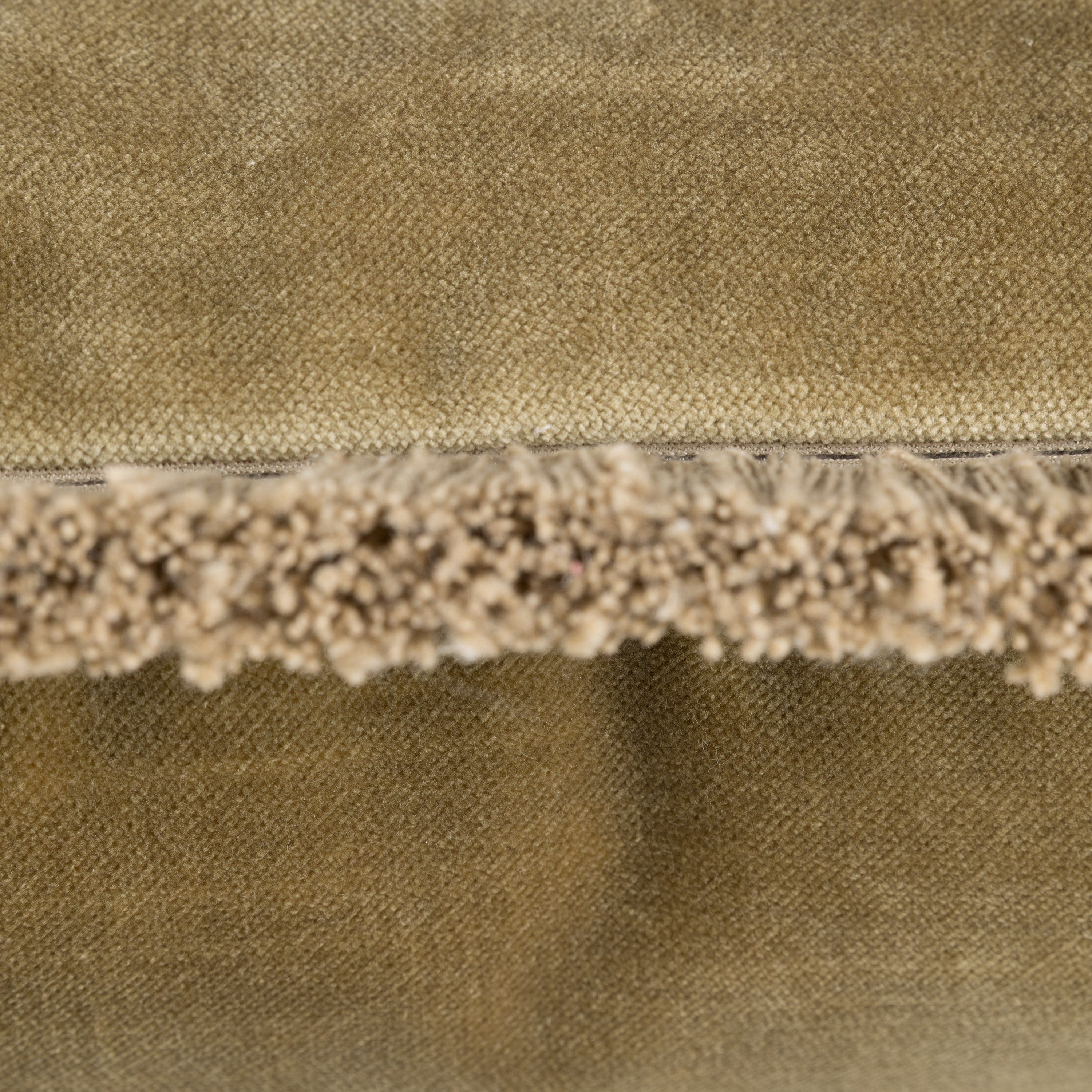Close-up of olive green fabric with tassel trim