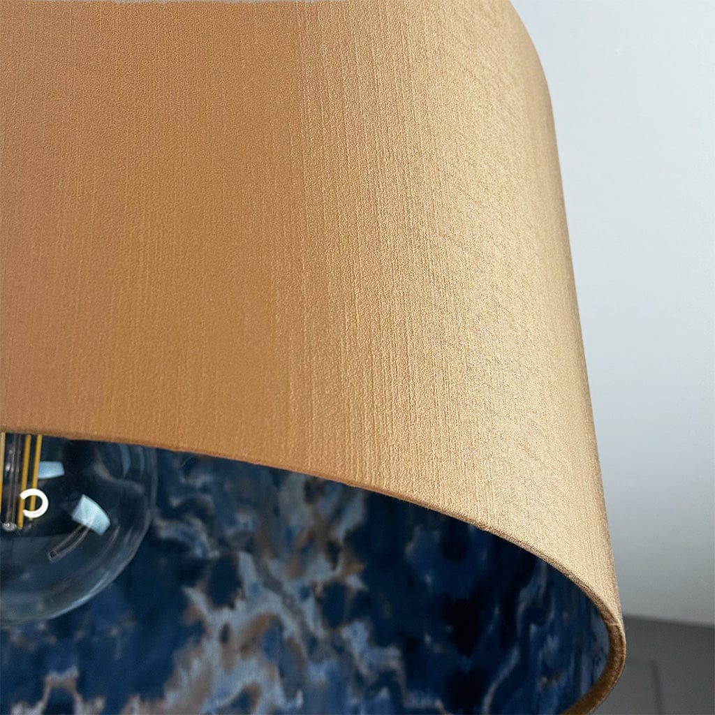 Close-up of a lampshade with a beige exterior and blue interior.