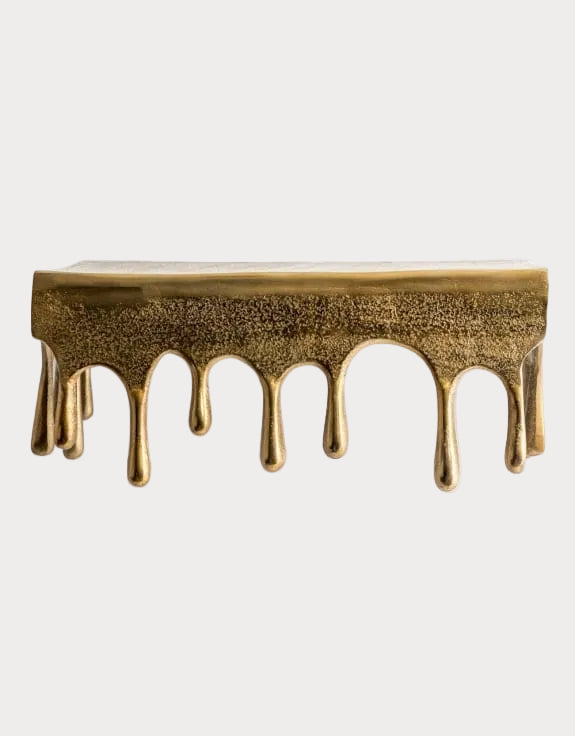 Decorative wall shelf with gold drippings on a white background