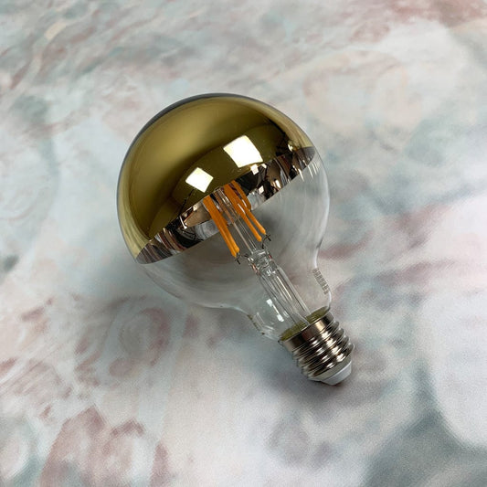 A dimmable LED light bulb with a gold top and clear glass bottom, designed for use in pendant shades.
