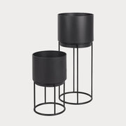 Two black circular planters with metal stands, one large and one small, displayed against a white background.