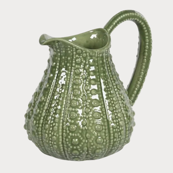 Green textured ceramic pitcher on a white background