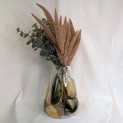Vase with green and brown plants on a white background