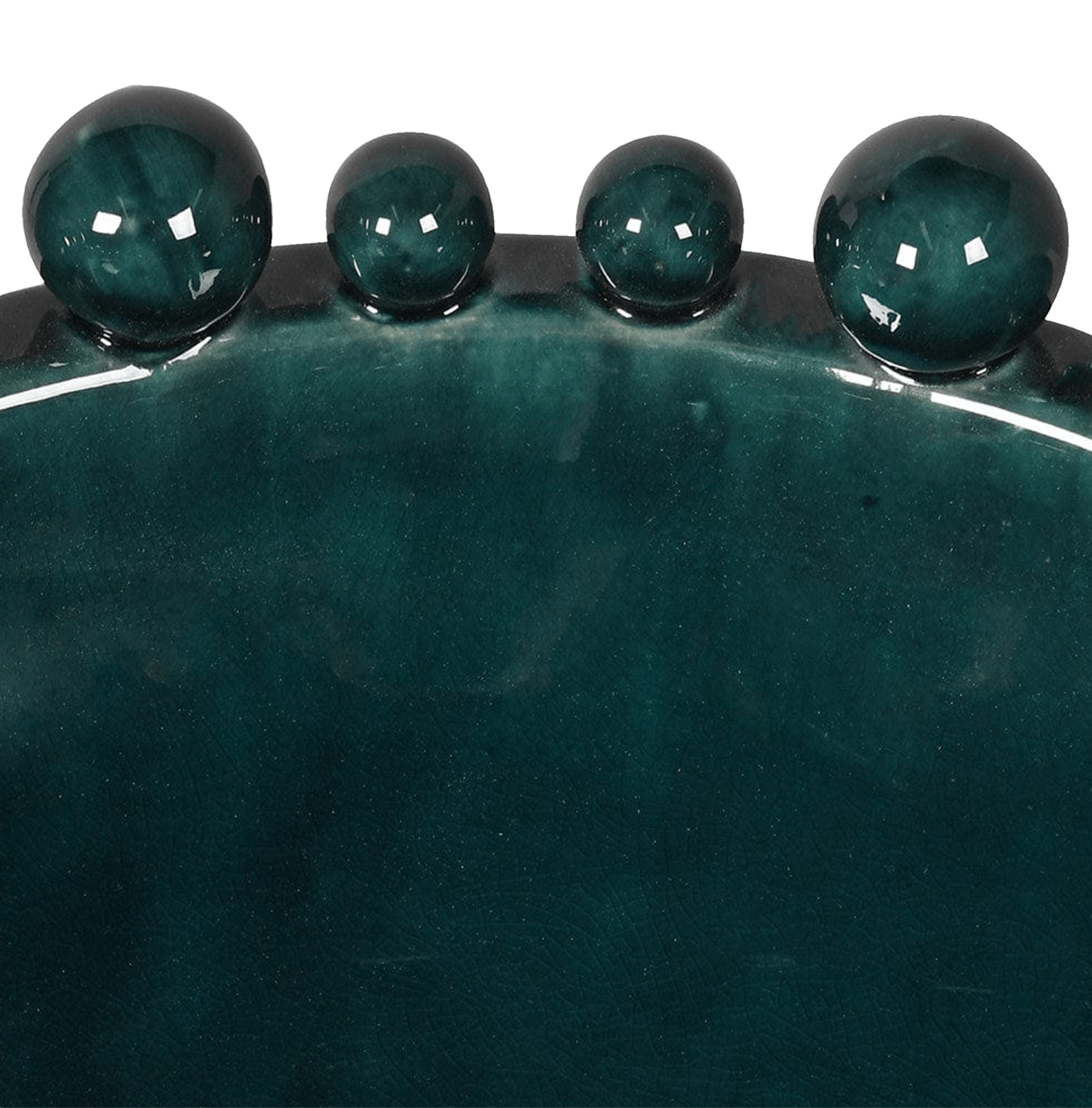 Close up A teal ceramic bowl with a glossy finish and decorative balls around the rim