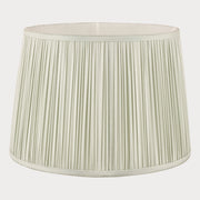 Light green pleated lampshade on a white background