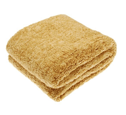 Folded beige throw on a white background