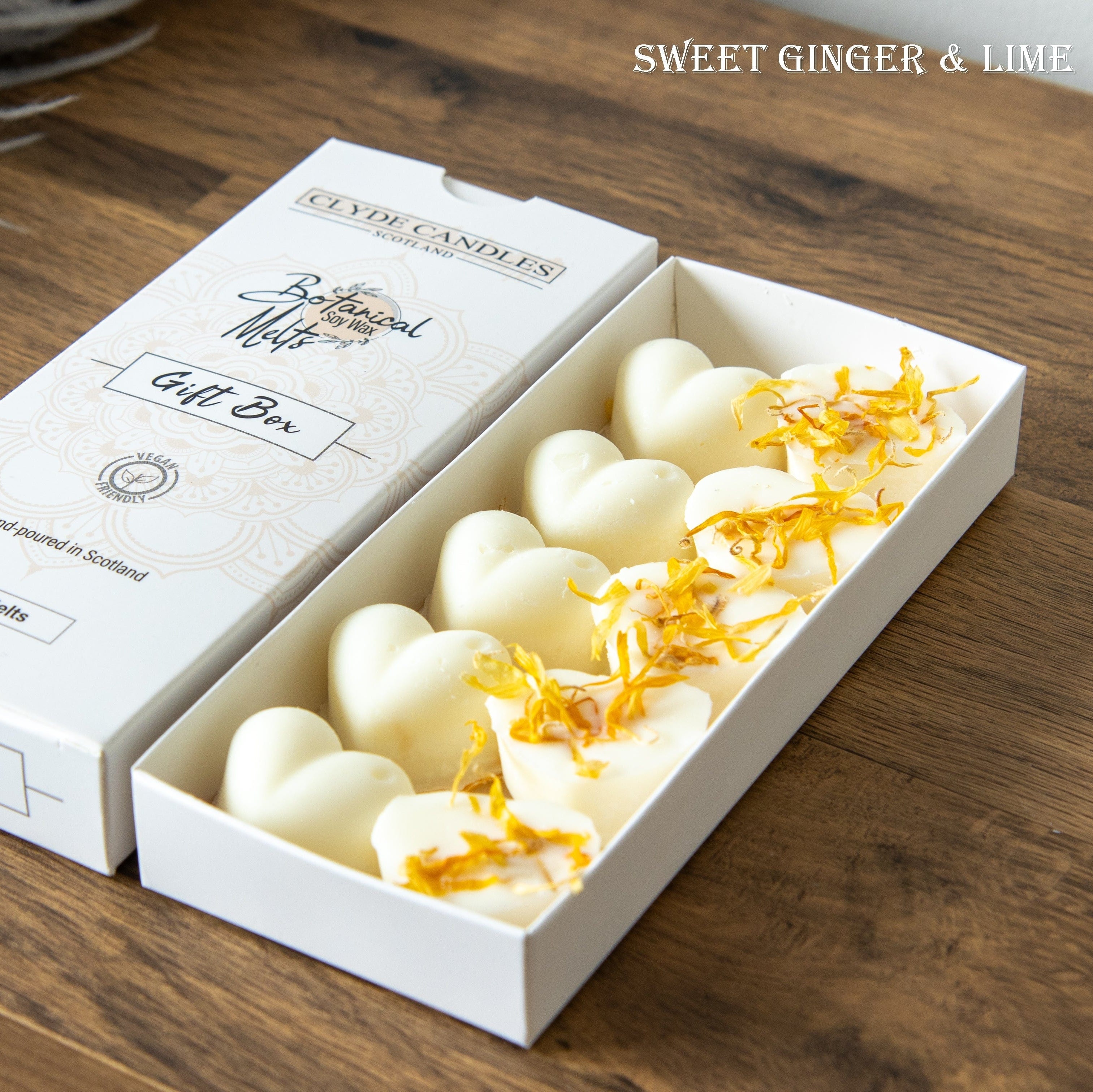 Box of heart-shaped candles with yellow accents on a wooden surface, featuring the brand 'Seyde Candles'.