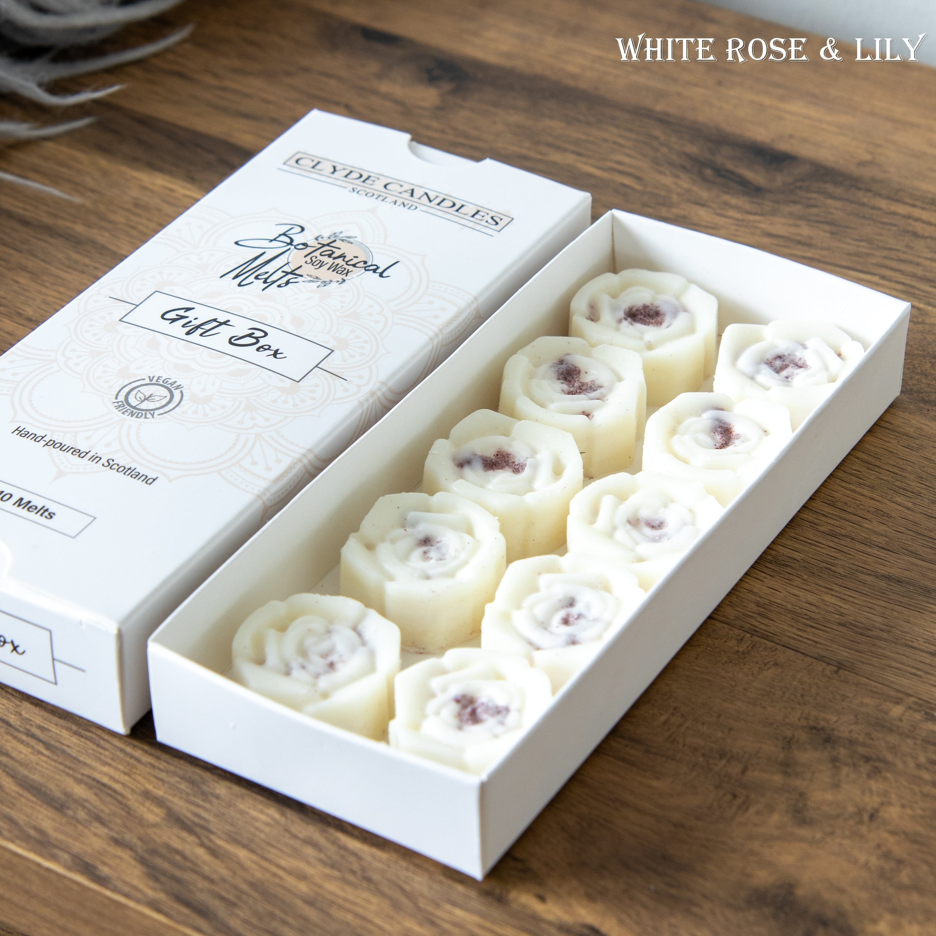 Box of Clyde Candles gift set on a wooden surface with 'White Rose & Lily' branding.