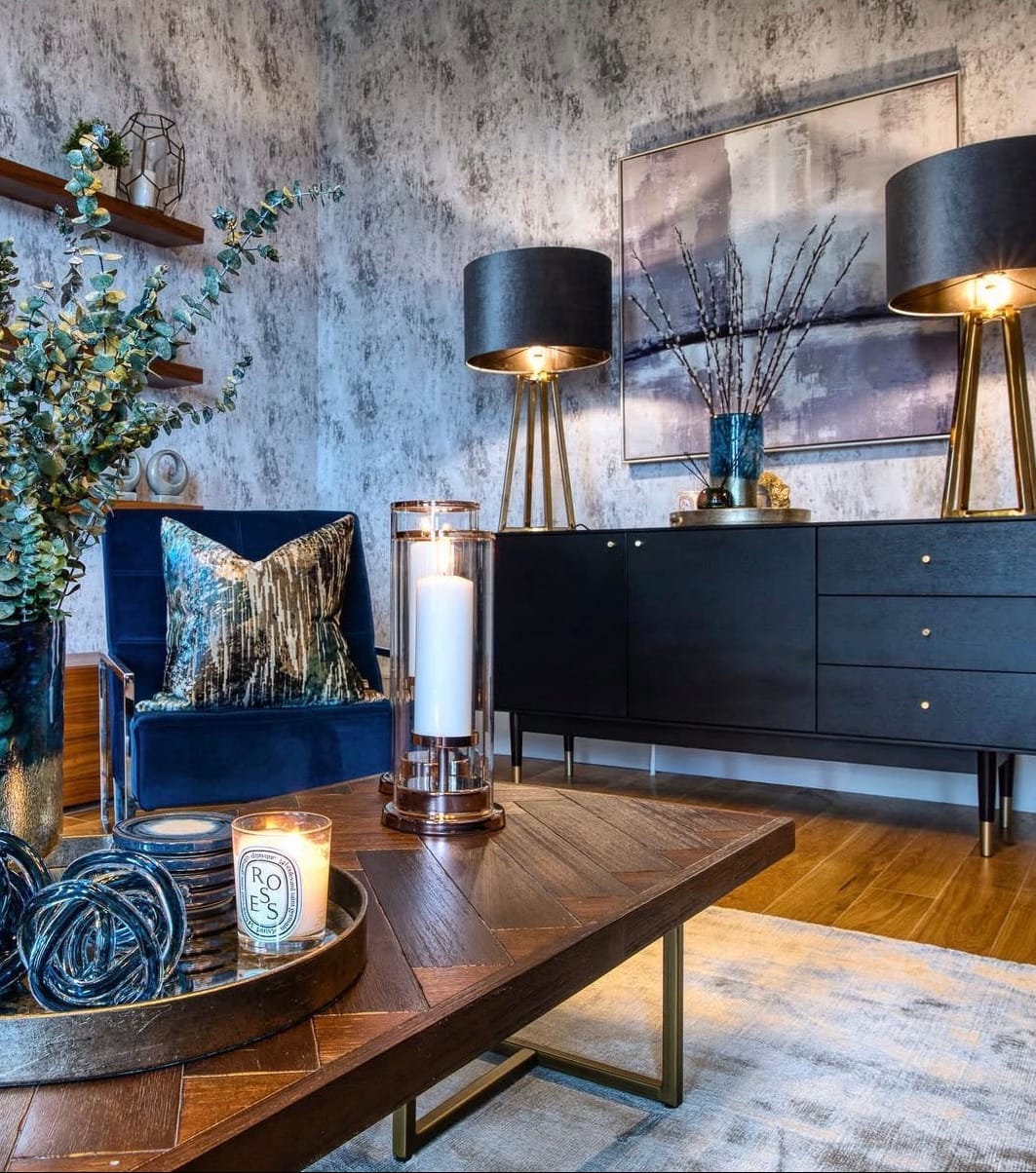 Modern living room with dark furniture, decorative items, and a textured wall.