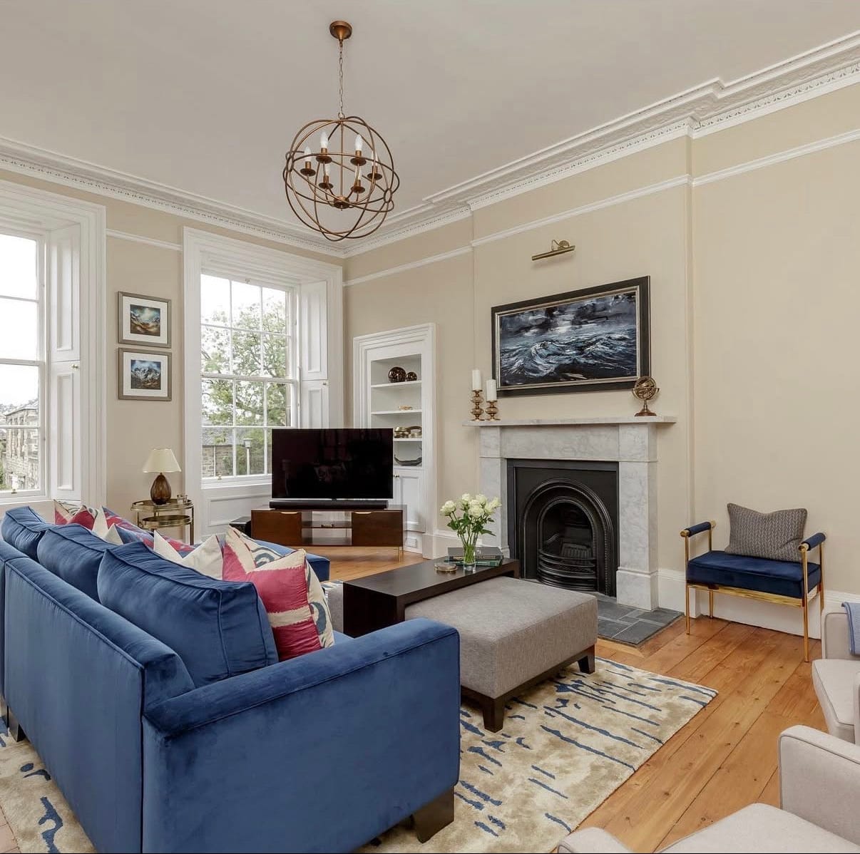 Living room with blue sofa, fireplace, and television in Edinburgh, United Kingdom.