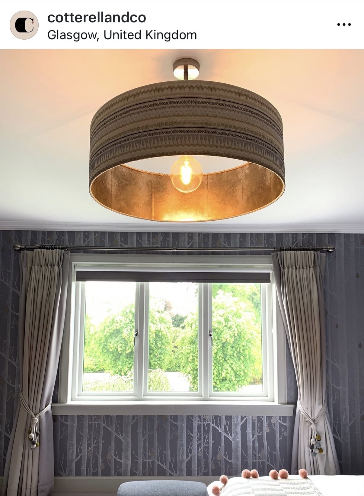 Ceiling light fixture in a room with a window and curtains
