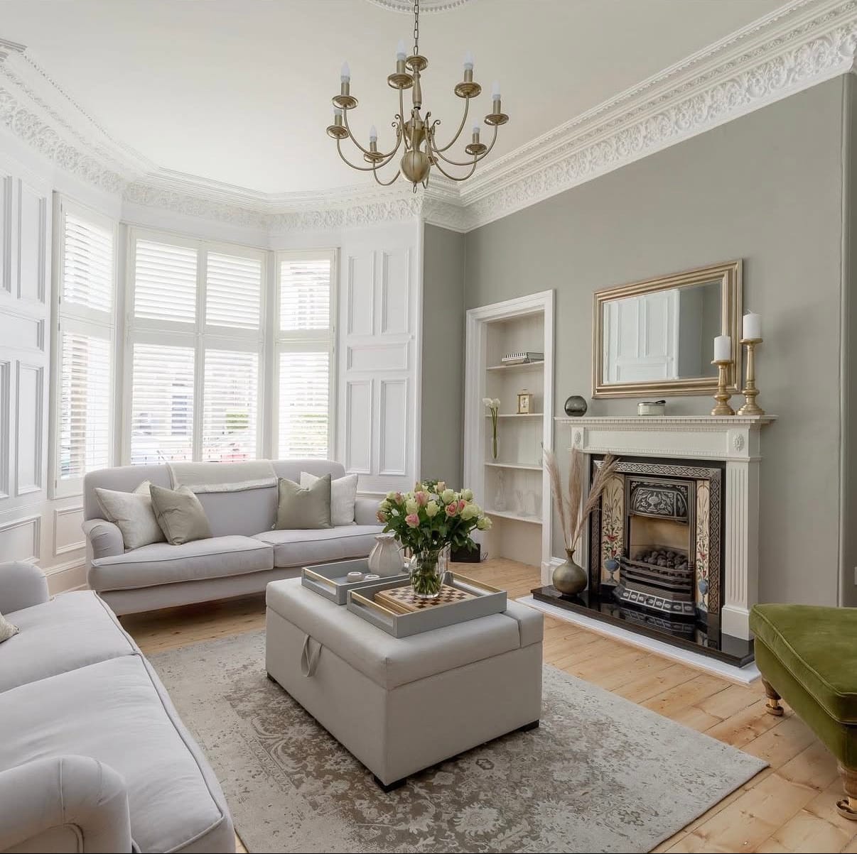 Living room with gray sofa, white ottoman, and fireplace in Edinburgh, United Kingdom.