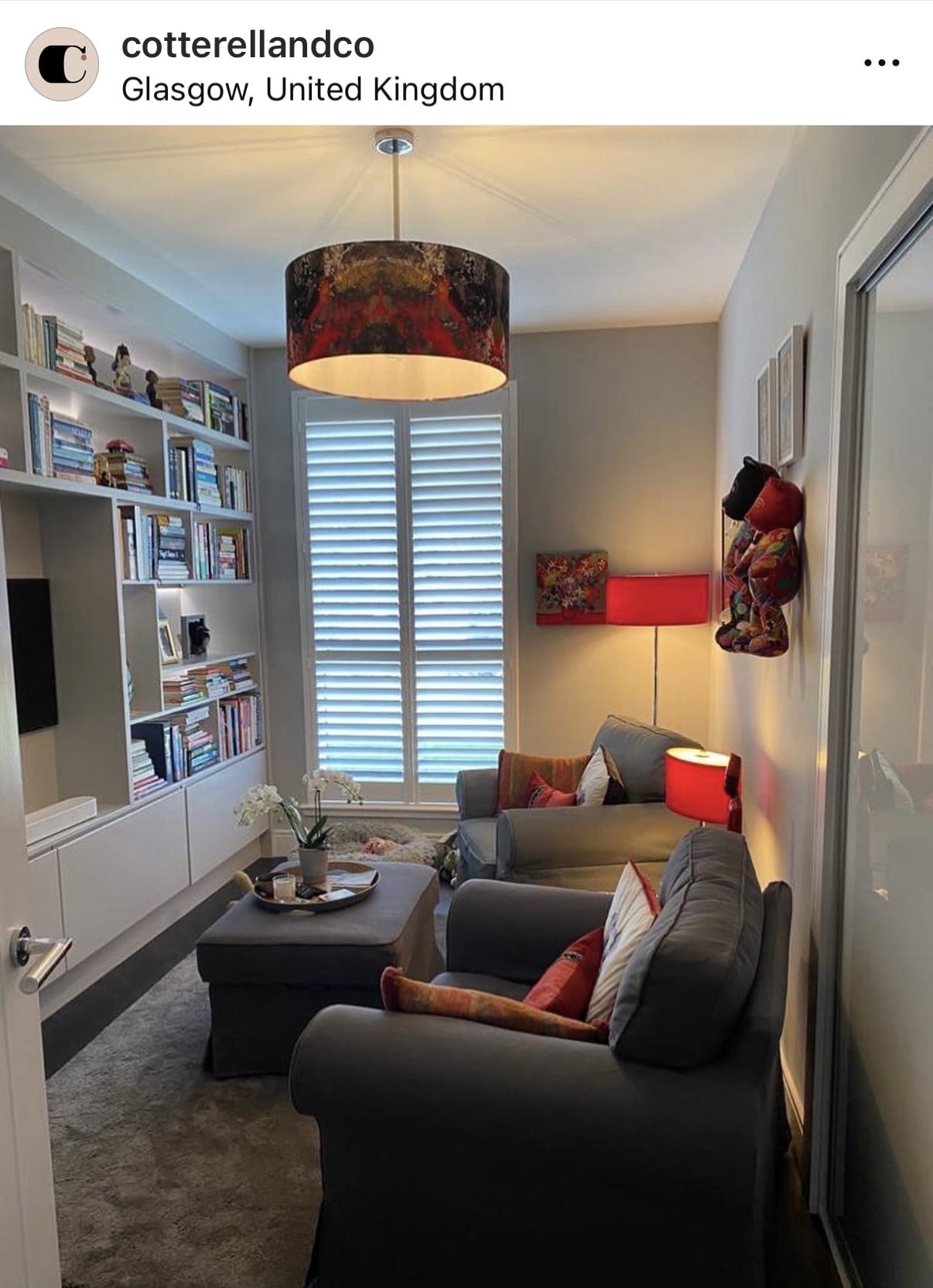 Living room with gray sofa, bookshelf, and decorative items.