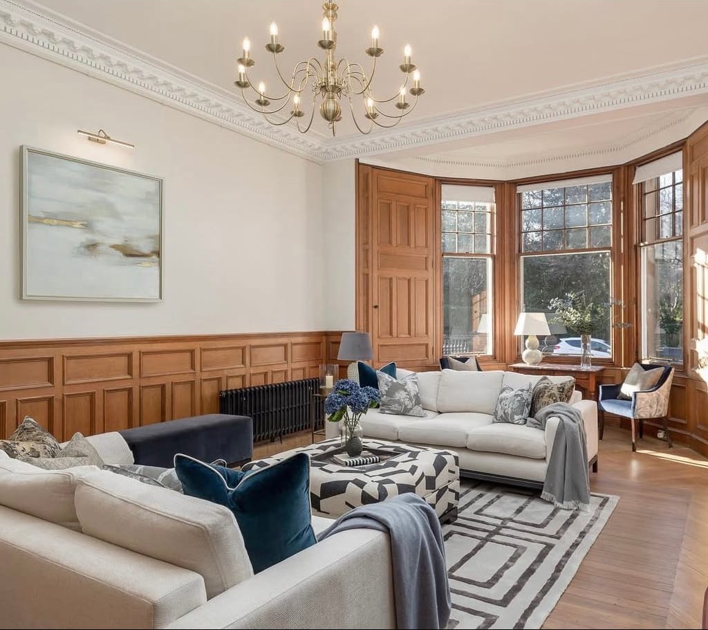 Luxurious living room with a chandelier, sofas, and large windows in Edinburgh, United Kingdom.