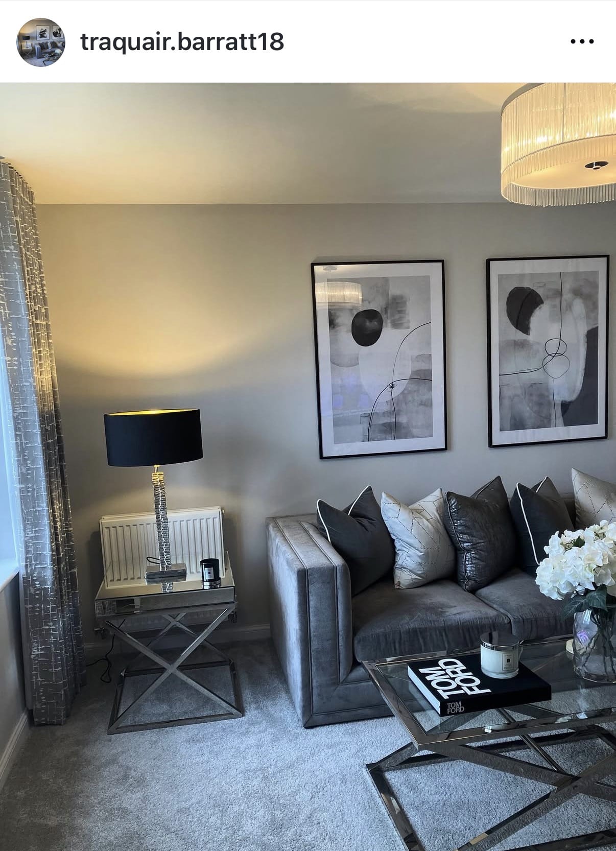 Living room with gray sofa, side table, lamp, and abstract art on the wall.