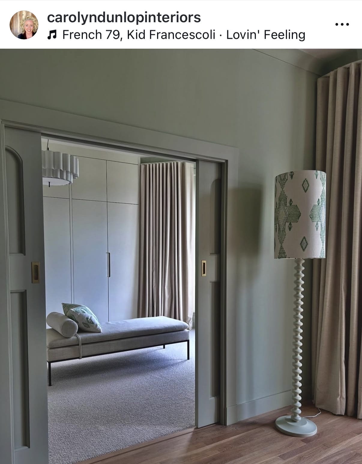 Living room with a sofa, lamp, and open door revealing another room.